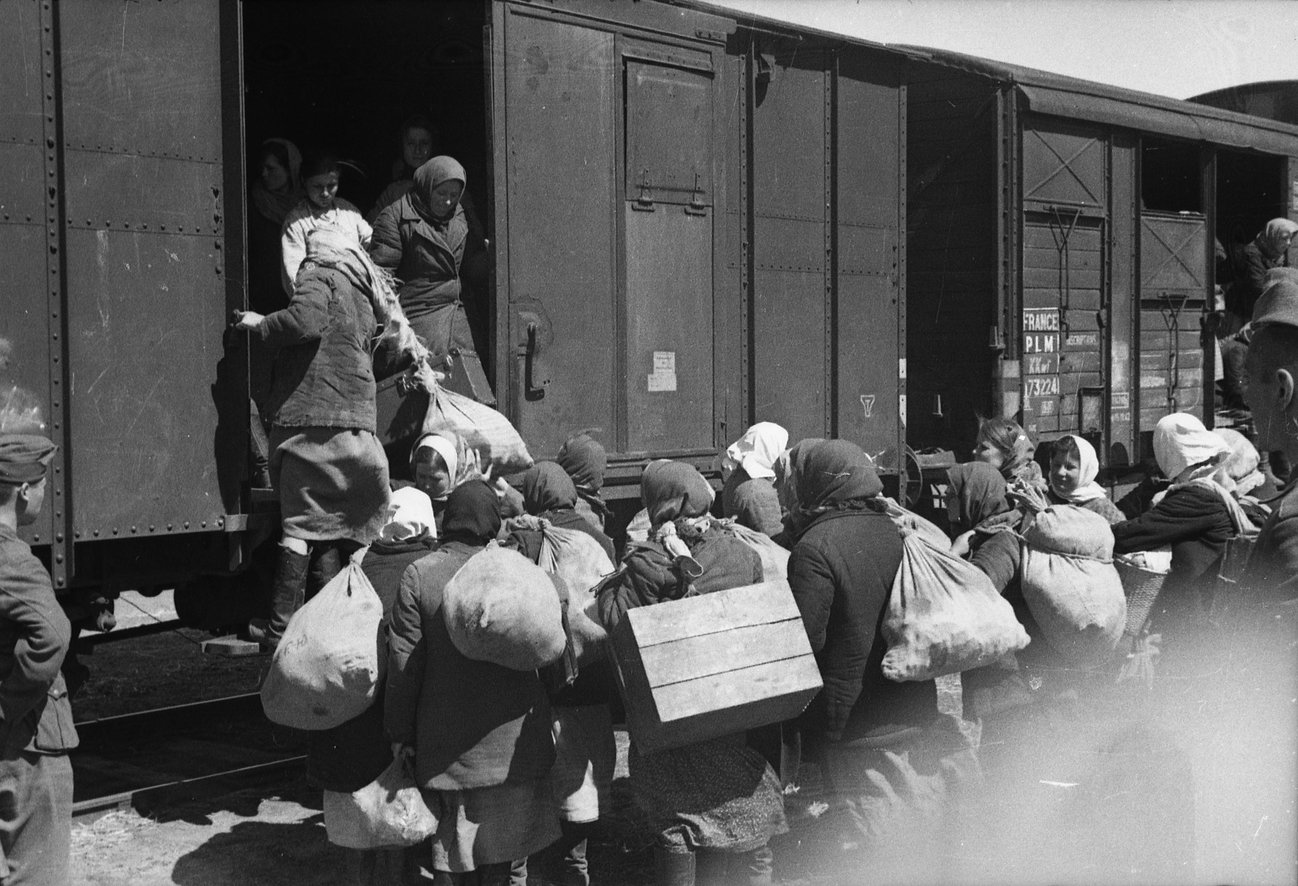 Ukrainerinnen, die zur Zwangsarbeit nach Deutschland verschleppt werden, steigen in Güterwaggons, 1943. Bundesarchiv Koblenz