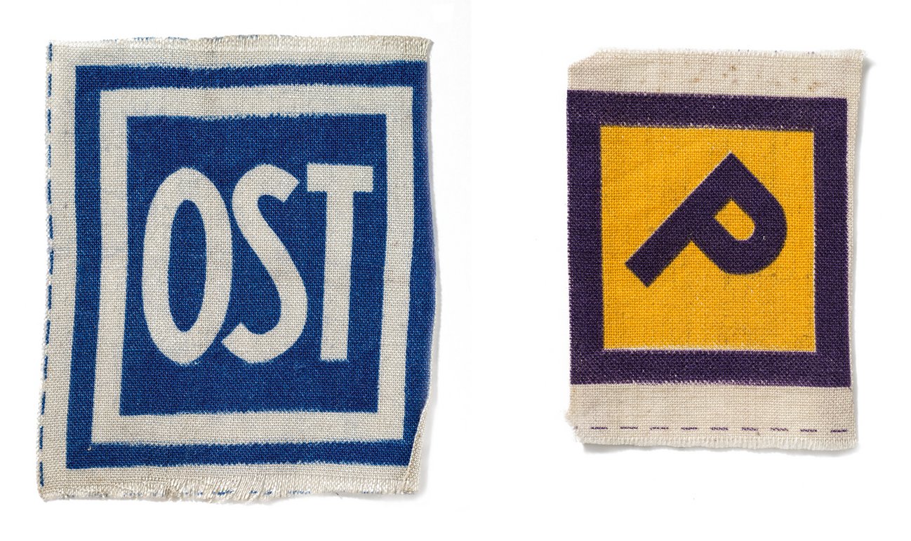 Abzeichen aus Stoff, die Zwangsarbeiter:innen aus der Sowjetunion und Polen gezwungen wurden zu  tragen. Dokumentationszentrum NS-Zwangsarbeit