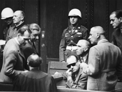 Die Angeklagten Rudolf Hess, Alfred Rosenberg, Hans Frank, Franz von Papen, Wilhelm Frick, Albert Speer und Alfred Jodl unterhalten sich in einer Pause w&auml;hrend der N&uuml;rnberger Prozesse, 1946, USHMM 