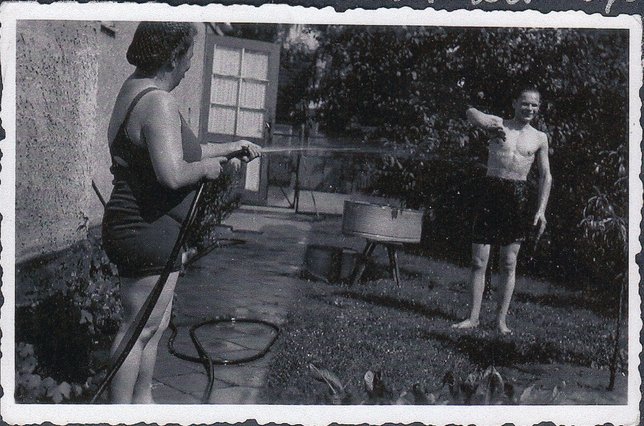 Die Tante von Elli Köhn, links im Bild, spritzt den Zwangsarbeiter Alexander Korodelow im Garten mit einem Schlauch nass, Dokumentationszentrum NS-Zwangsarbeit